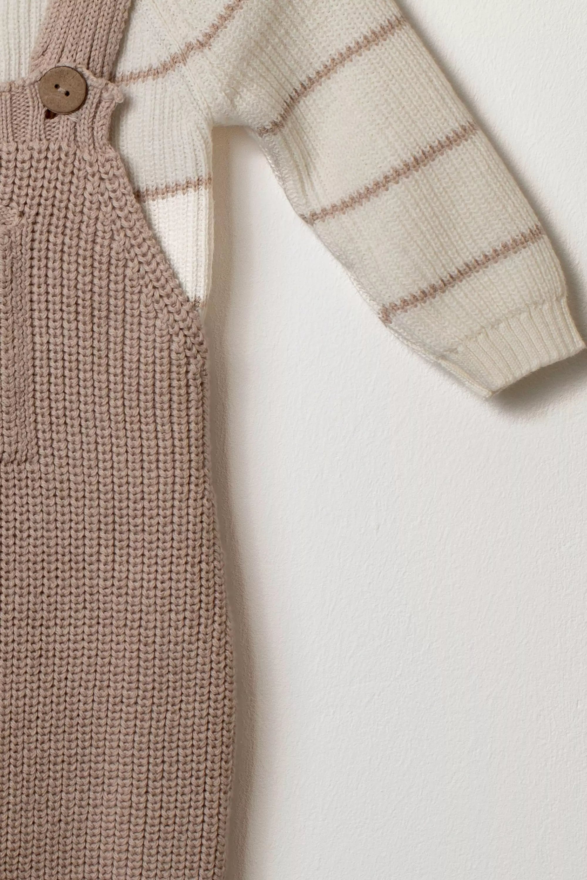 Nahaufnahme Baby Strickset taupe Latzhose Pullover Ärmel gestreift