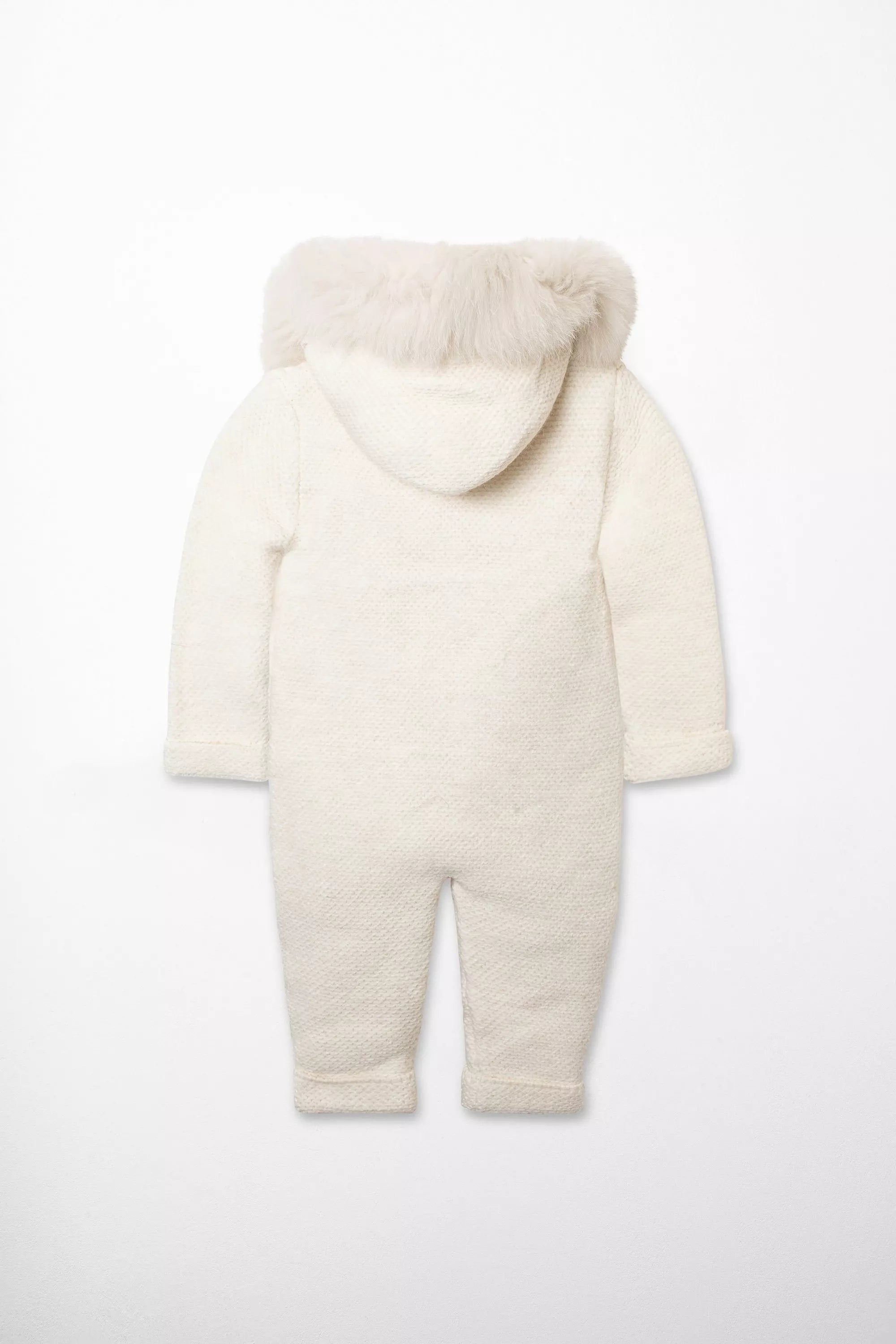 Rückansicht des warmen Strick-Overalls für Babys in Weiß/Creme mit Kapuze