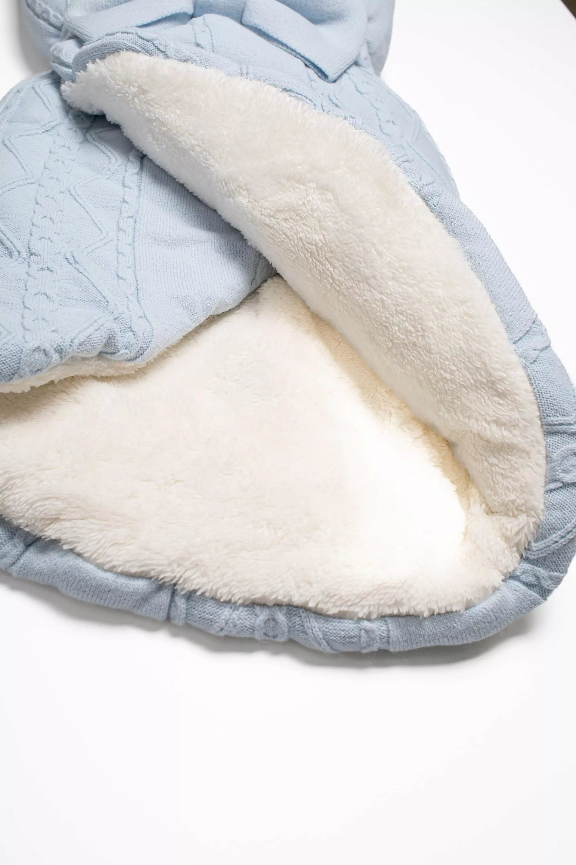 Detailansicht des weißen Teddyfutters der hellblauen Baby Einschlagdecke.