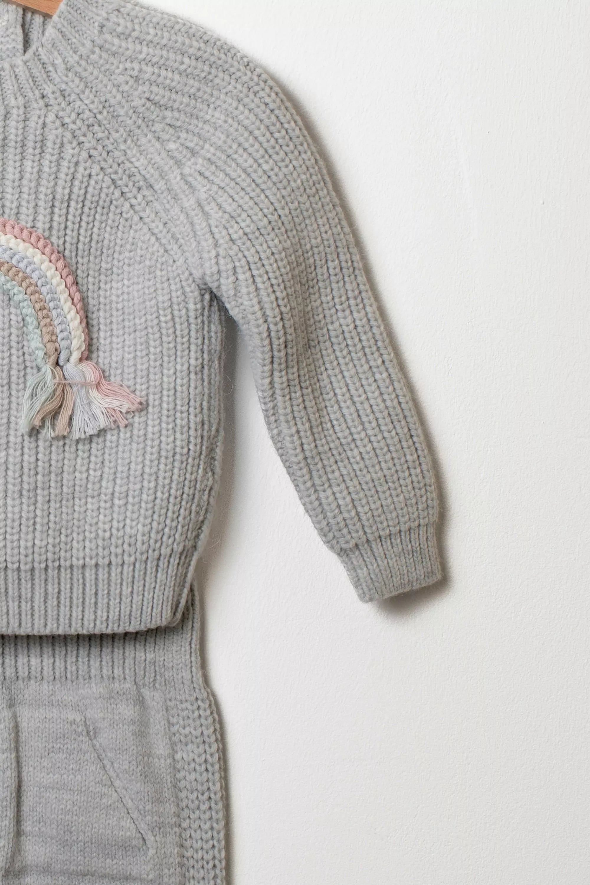 Detailaufnahme Strickpullover grau mit Regenbogen Ärmel und Raglanstrick
