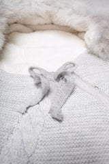 Nahaufnahme des Strick-Baby-Schlafsacks in Grau mit Zopfmuster und Schleifenverschluss