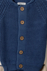 Nahaufnahme der Knopfleiste des marineblauen Baby Strick-Cardigans mit Holzknöpfen und deutlicher Strickstruktur.