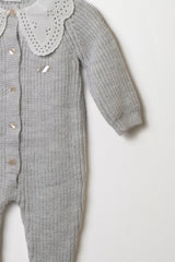 Detailansicht des Ärmels und des Lochstickerei-Kragens des grauen Baby Strick-Overalls.