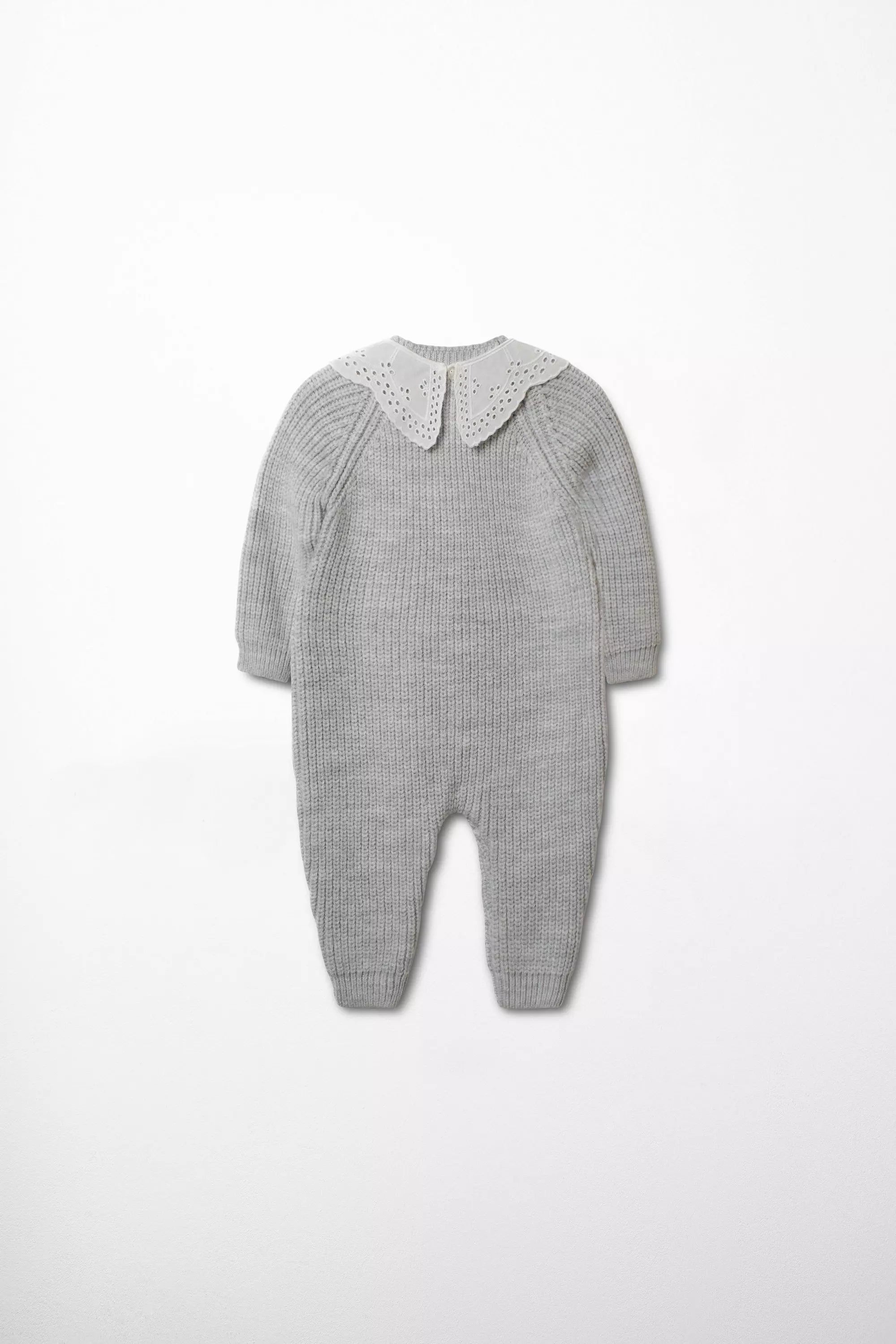 Rückansicht des grauen Baby Strick-Overalls mit weißem Lochstickerei-Kragen.
