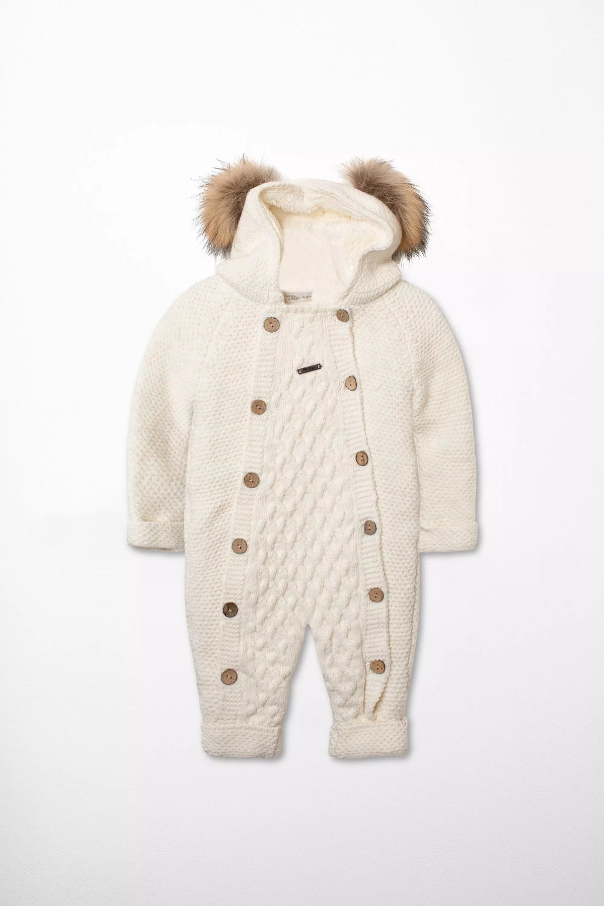 Vorderansicht des warm gefütterten Baby Strick-Schneeanzugs in Weiß mit Zopfmuster, Kapuze mit Webpelz-Ohren und doppelter Knopfleiste.