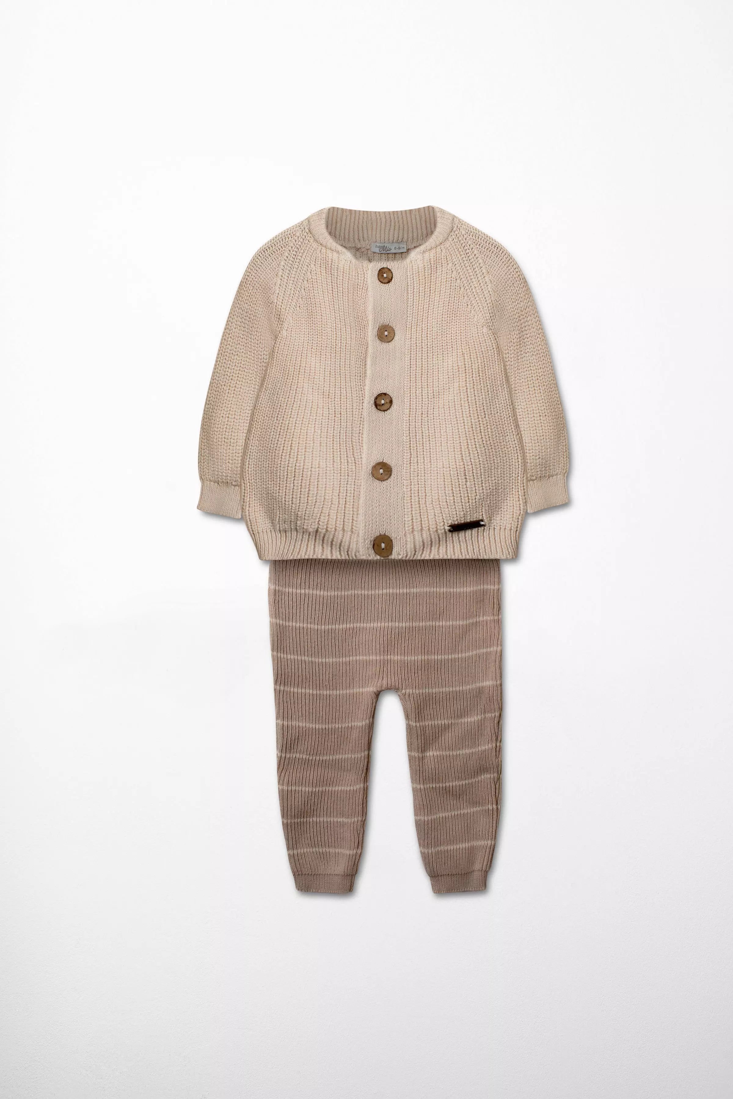 Vorderansicht des Baby Strick-Sets: Cardigan in Beige/Natur mit Holzknöpfen und Hose in Braun mit Ripp-Struktur.