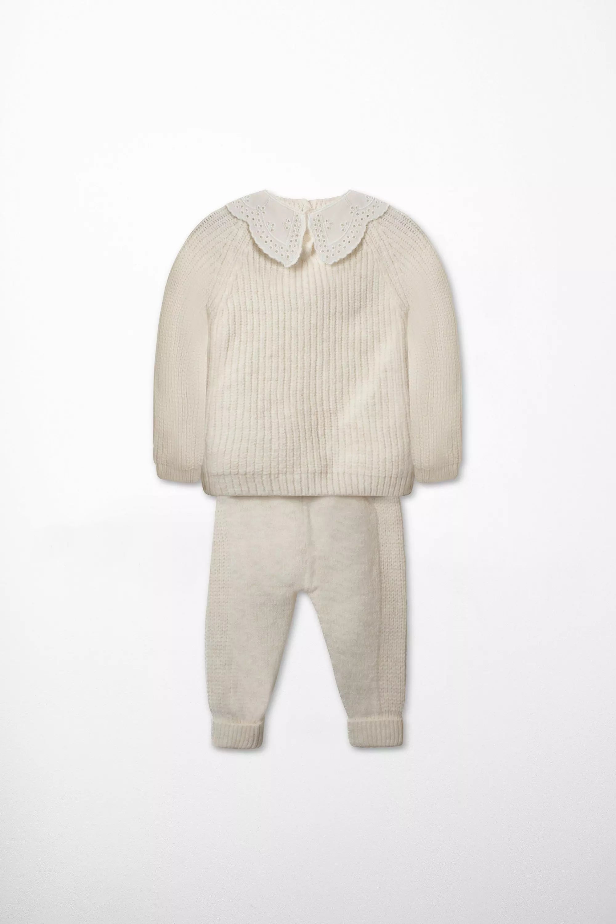 Rückansicht des Baby Strick Sets in Creme mit Pullover und Hose und weissem Bubikragen