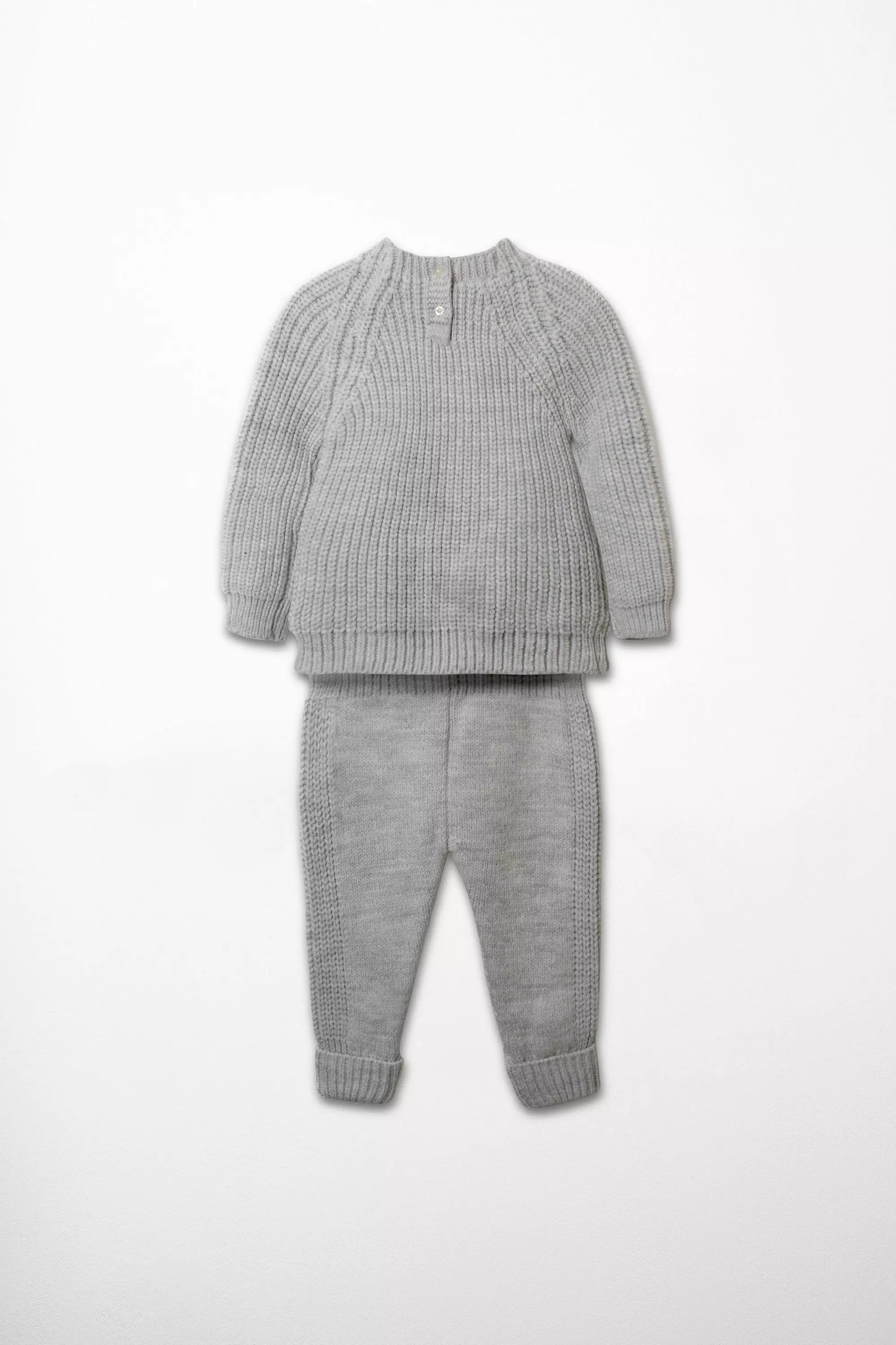 Rückansicht Strickmode Set grauer Pullover mit Knopfverschluss und Hose