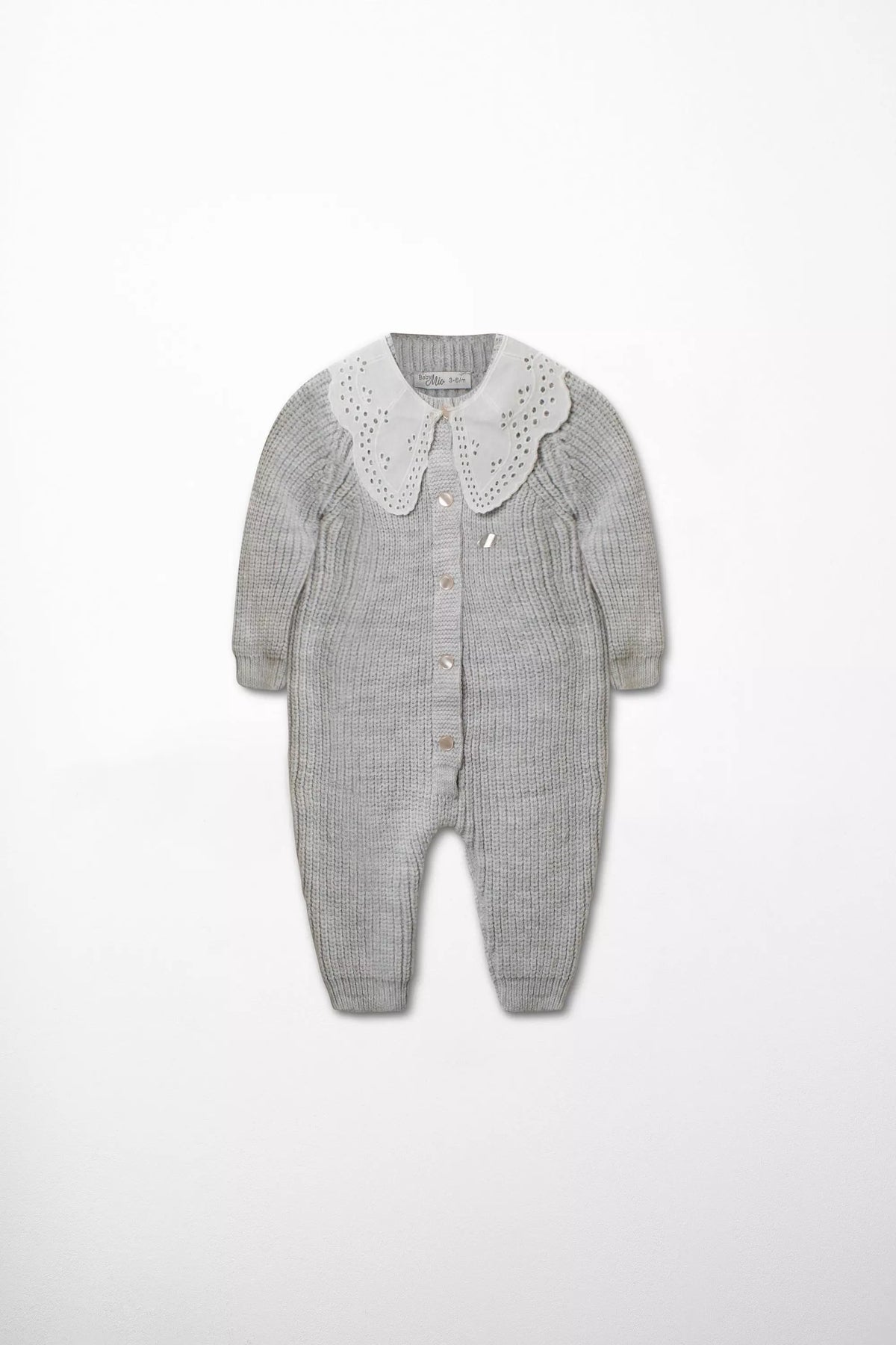 Vorderansicht des Baby Strick-Stramplers in Grau mit großem weißen Kragen mit Lochstickerei und Perlmutt-Knöpfen.