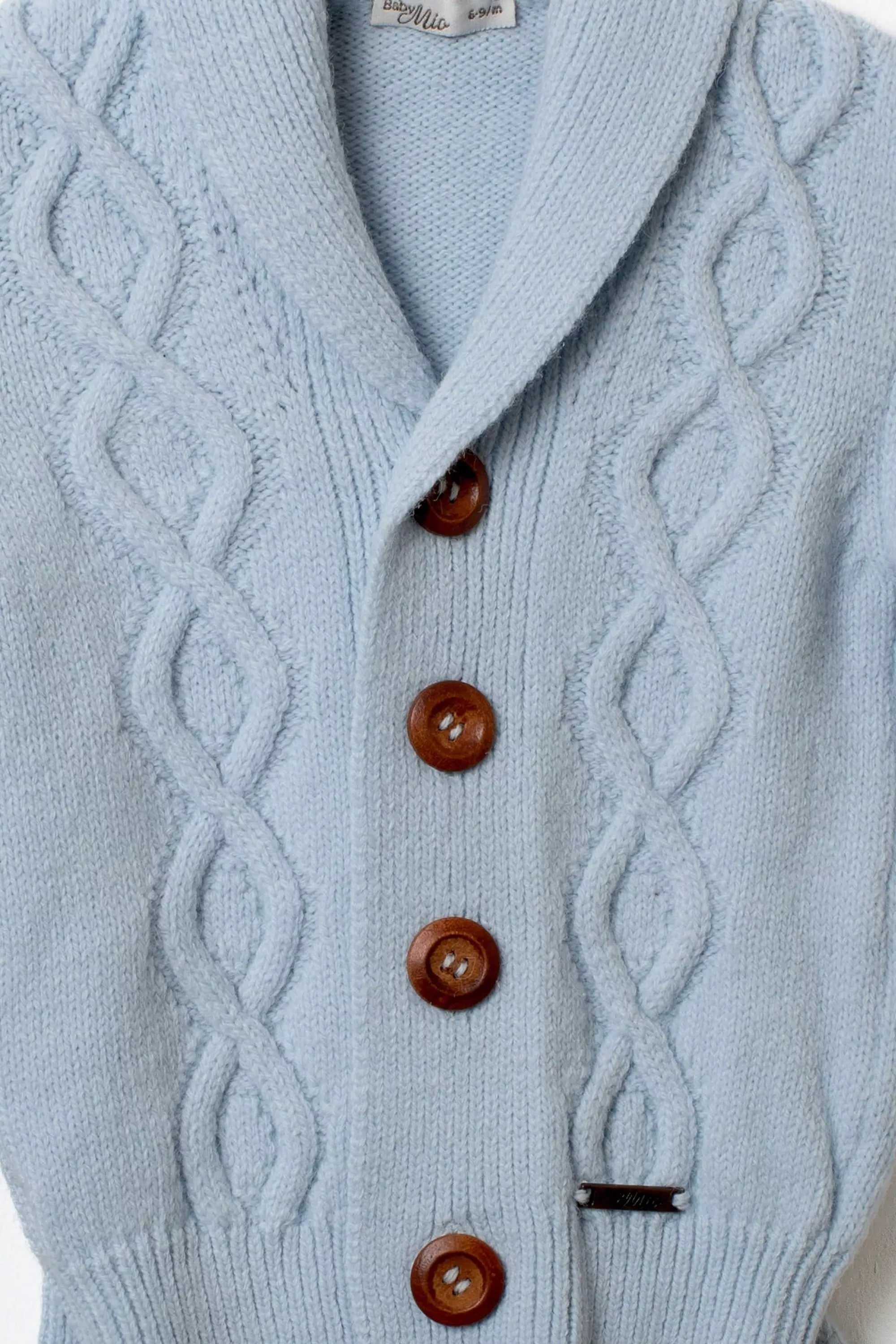 Nahaufnahme Strickjacke hellblau Schalkragen Holzknöpfe Zopfmuster