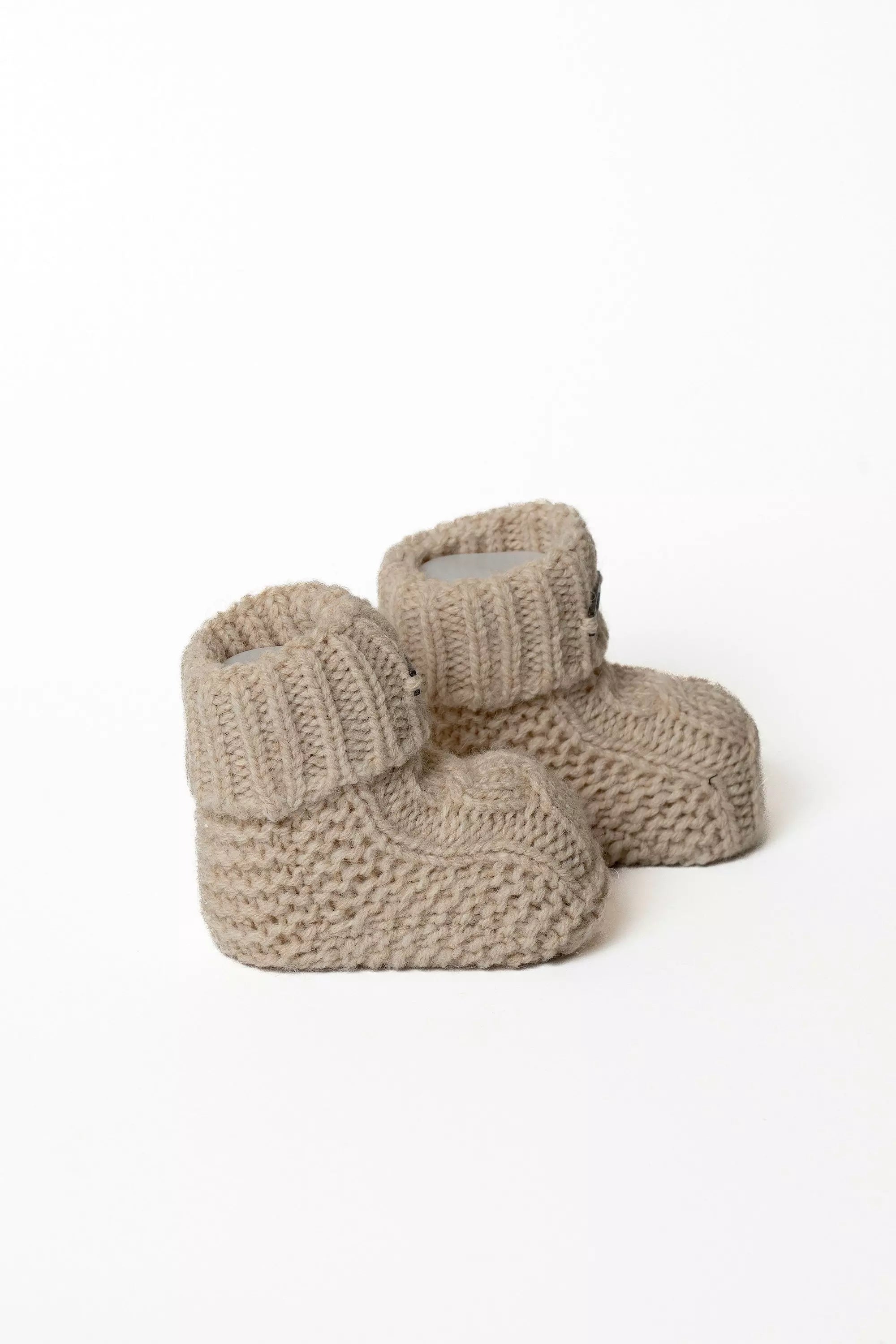 Paar beige Baby Strickschuhe von Noblekids, gestrickte Winter Booties für Babys, Schräge Ansicht