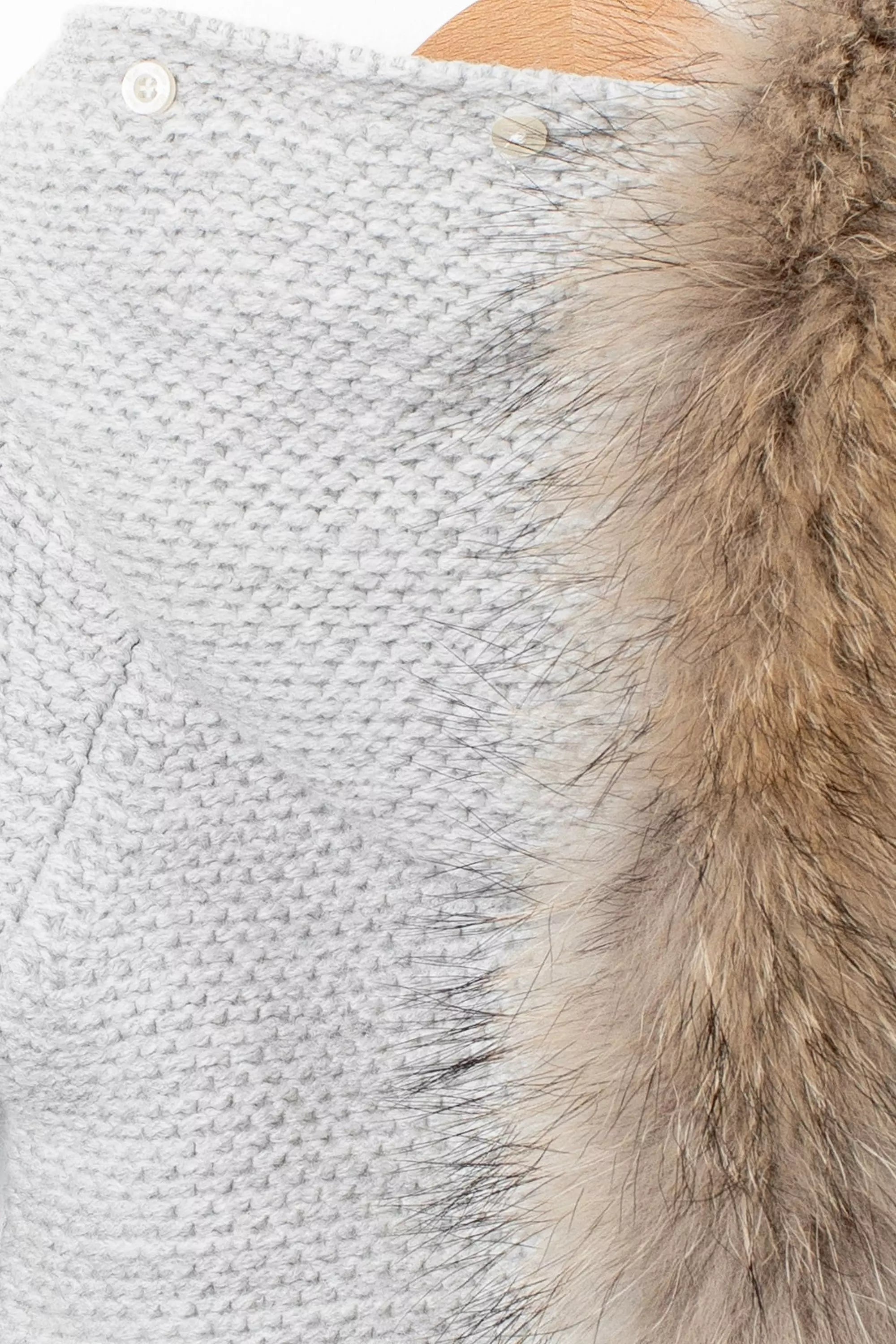 Detailaufnahme der Kapuze des grauen Stramplers mit abnehmbarem Fellbesatz und Knöpfen