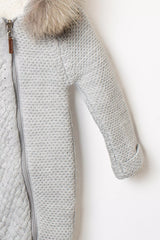 Detailaufnahme des Ärmels und Reißverschlusses eines grauen Stramplers