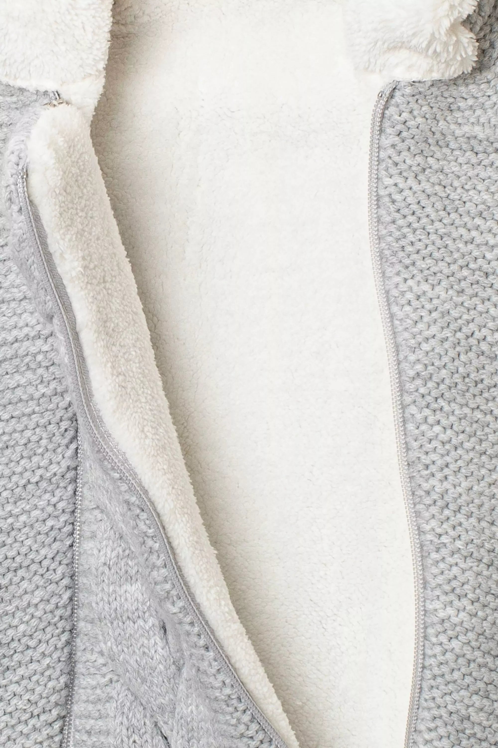 Detail des geöffneten Baby Strickstramplers in Hellgrau mit weissem kuscheligem Fleecefutter und Reissverschluss