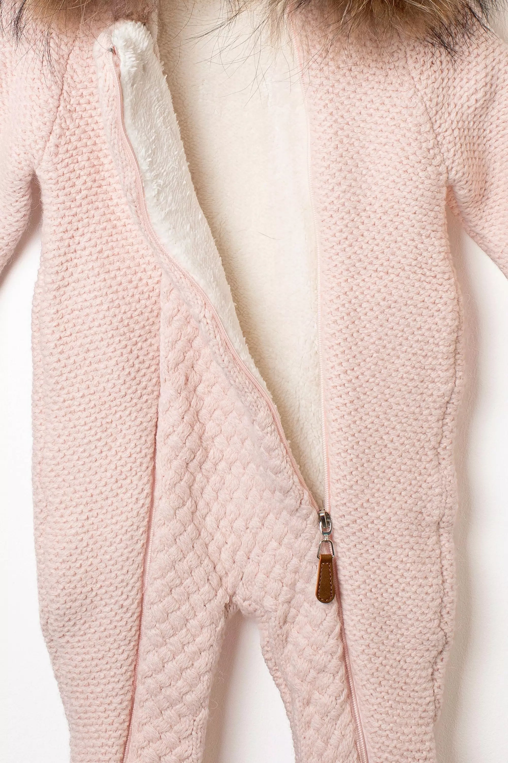 Detail des geöffneten Baby Strickstramplers in Rosa mit weissem kuscheligen Fleecefutter und Reissverschluss
