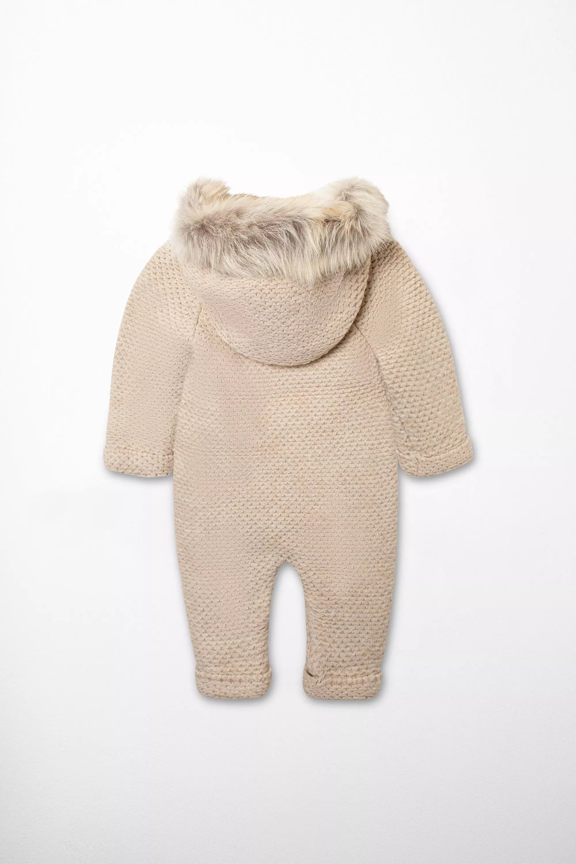 Rückansicht des beigen Baby Winter-Overalls aus Strick mit gefütterter Webpelz-Kapuze und feiner Strickstruktur.