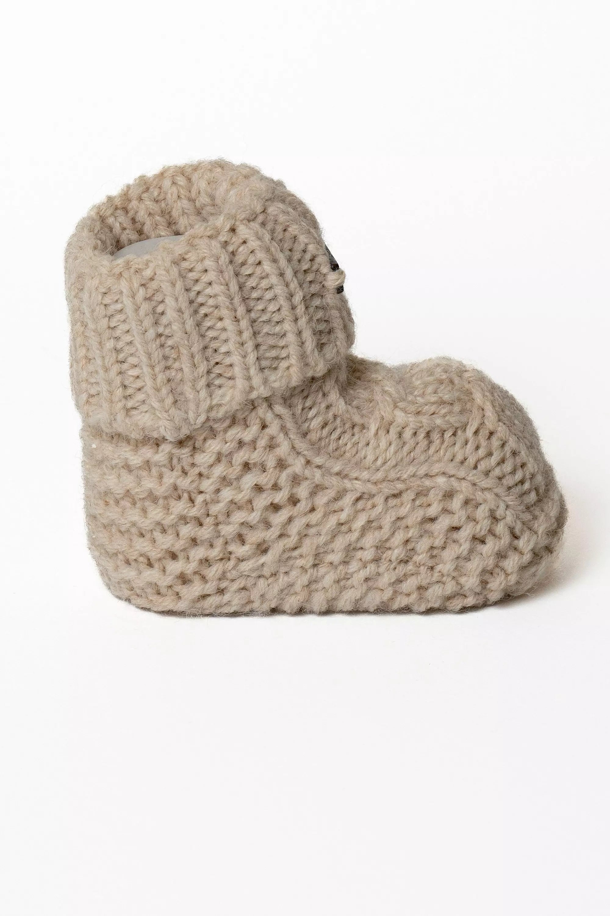 Einzelner beiger Baby Strickschuh, Seitliche Ansicht mit dickem Strick und Umschlag
