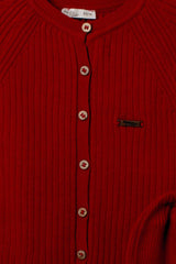 Nahaufnahme der Knopfleiste des roten Baby-Overalls mit Holzeffekt-Knöpfen und Logo-Emblem