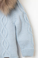 Nahaufnahme des Ärmels der hellblauen Baby-Strickjacke, mit detailreichem Zopfmuster und Rippbündchen