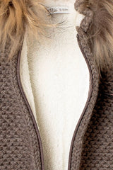 Nahaufnahme des weißen, flauschigen Teddyfell-Innenfutters und des Reißverschlusses der Baby Strickjacke