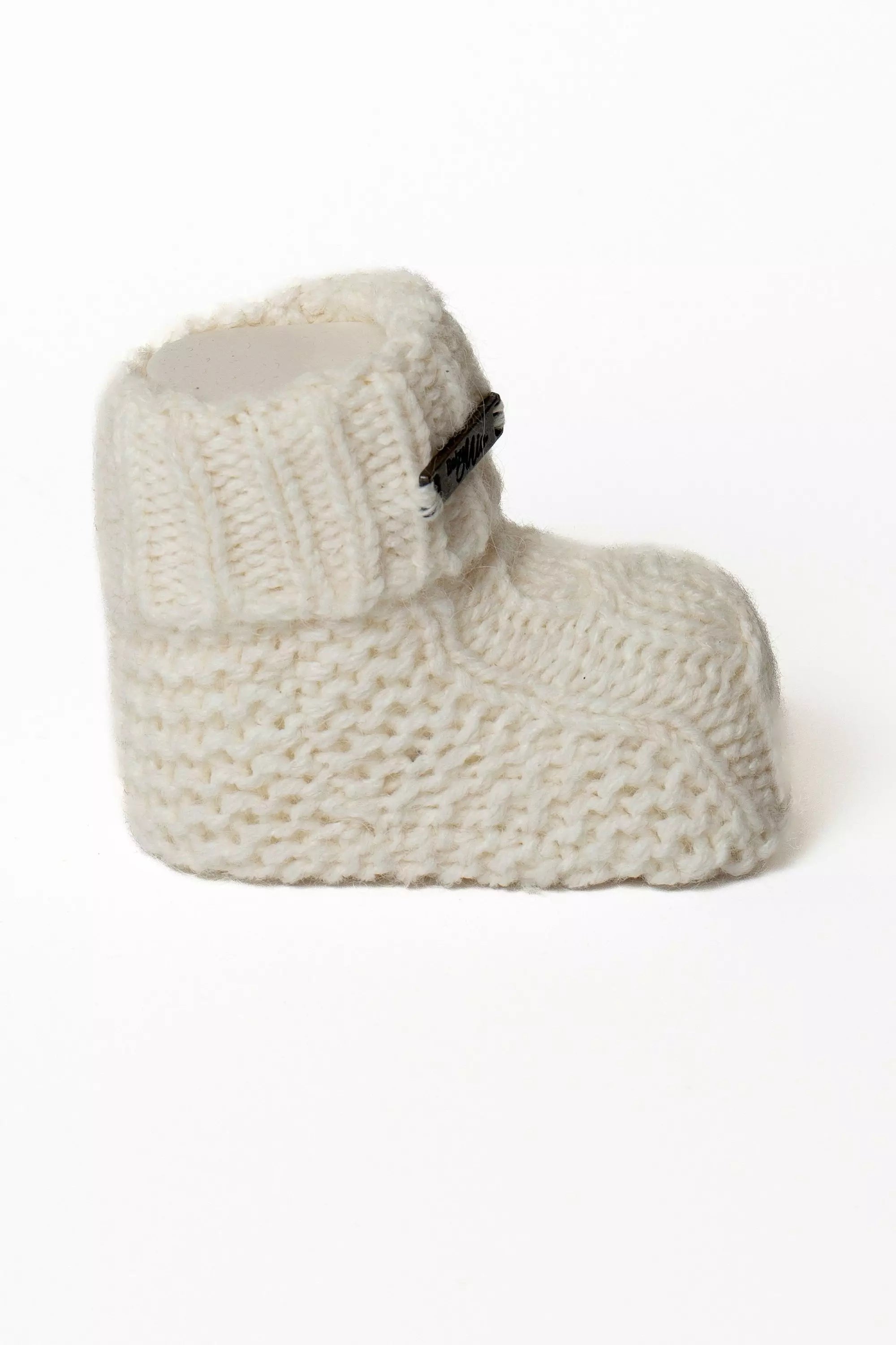 Einzelner weisser Baby Strickschuh, Seitliche Ansicht mit Rippstrickbund und Label